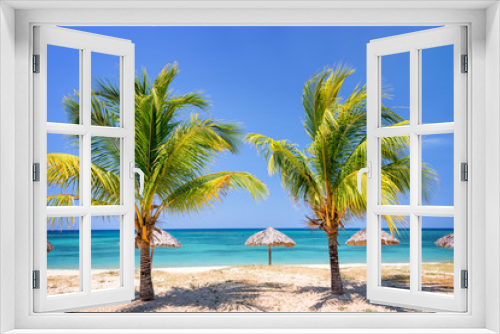 Fototapeta Naklejka Na Ścianę Okno 3D - Straw umbrellas and palm trees on a beautiful tropical beach