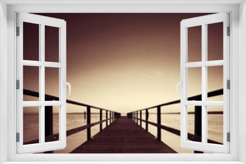 Fototapeta Naklejka Na Ścianę Okno 3D - Long Wooden Pier into a Lake, perfect symmetry, black and white, sepia toned