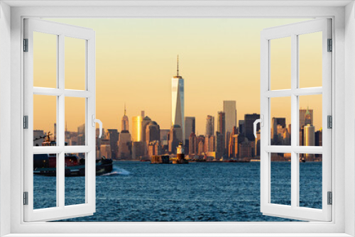 Panoramic Sunset of Lower Manhattan and New York City Harbor with Financial District skyscrapers and passing tugboat