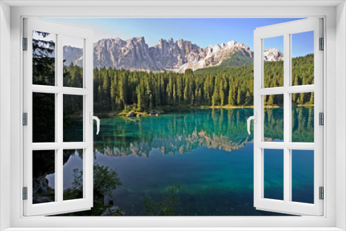 Fototapeta Naklejka Na Ścianę Okno 3D - Lago di Carezza, an extremely clear lake in the Dolomites of Northern Italy. Visibility more than 30 feet down to see logs, fish and sand. Also known as Rainbow Lake.