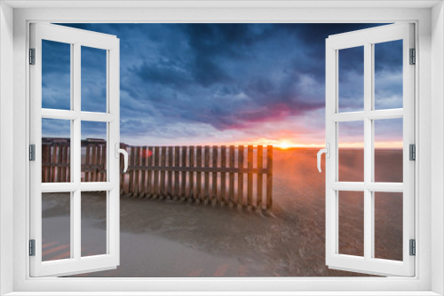 Fototapeta Naklejka Na Ścianę Okno 3D - wooden fences on beach in Tarifa, sunset after dramatic storm
