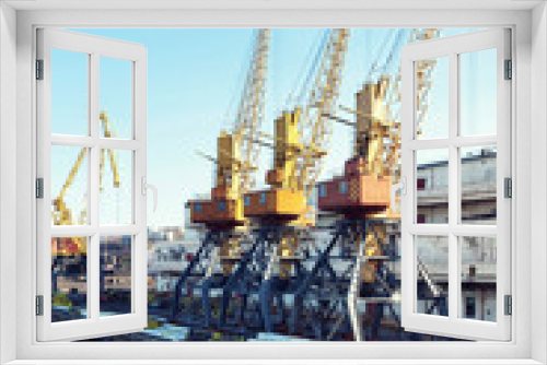 Fototapeta Naklejka Na Ścianę Okno 3D - Port cargo crane over blue sky background. Sea port, crane for loading at sunset. Transportation