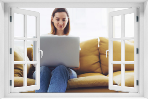 Attractive female is typing messages on a laptop while sitting at home,  Hipster girl working on a portable computer from home