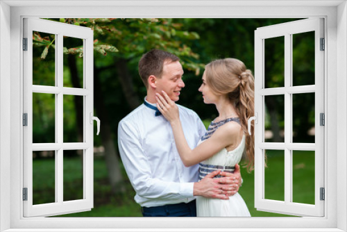 A married couple is walking and hugging in the park.