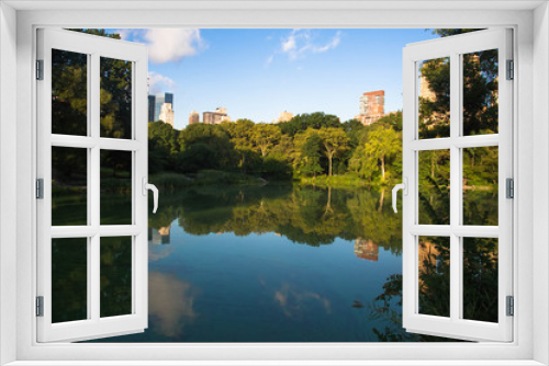 Fototapeta Naklejka Na Ścianę Okno 3D - Buildings in Manhattan and trees reflect on the lake at Central Park