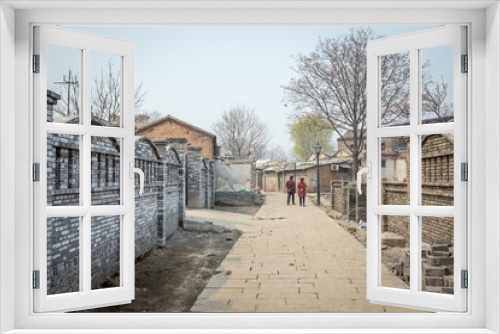 Fototapeta Naklejka Na Ścianę Okno 3D - un couple se promène dans les rues d'un vieux quartier de Pékin