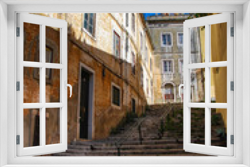 Fototapeta Naklejka Na Ścianę Okno 3D - Steep stairs of Lisbon between historic building with rustic yellow facades