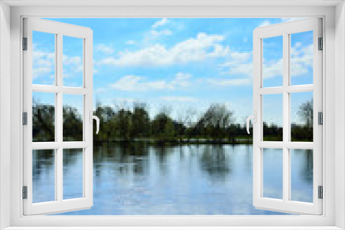 Fototapeta Naklejka Na Ścianę Okno 3D - Rzeka i brzeg z trawą z niebem z chmurami.