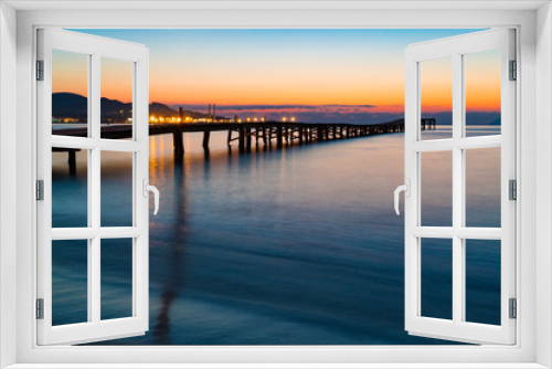 Fototapeta Naklejka Na Ścianę Okno 3D - Sunset on a sandy beach and a wooden pier, Panorama