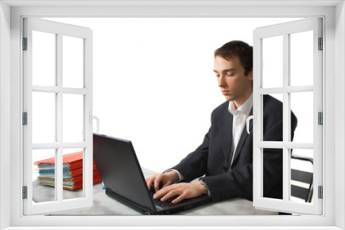 Young man works on laptop, side view