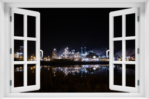 Fototapeta Naklejka Na Ścianę Okno 3D - Lights of petrochemical refinery at night reflecting in water. Tessenderlo, Belgium