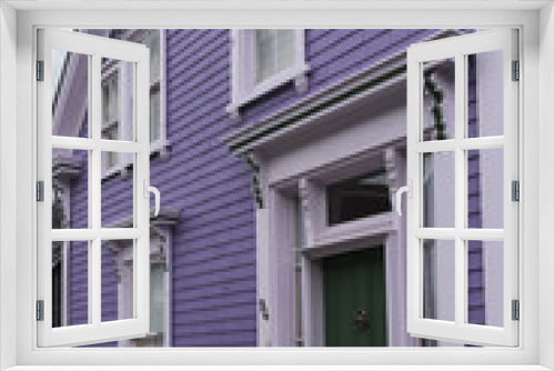 Fototapeta Naklejka Na Ścianę Okno 3D - Green door with white frame, and lilac colored walls in Lunenburg, Nova Scotia, Canada