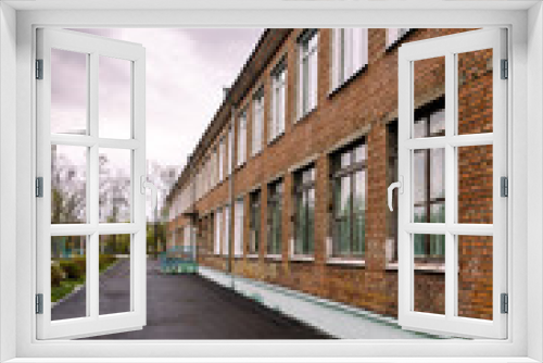 Fototapeta Naklejka Na Ścianę Okno 3D - Schoolyard, brick school on a cloudy day