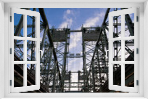 Fototapeta Naklejka Na Ścianę Okno 3D - Bridge with steel trusses and lifting towers on a wide concrete support