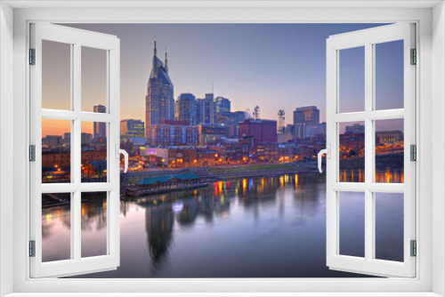 Fototapeta Naklejka Na Ścianę Okno 3D - Skyline of Nashville, Tennessee at sunset showing reflections in the Cumberland River