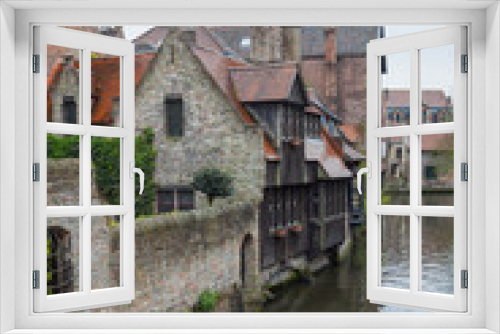 Fototapeta Naklejka Na Ścianę Okno 3D - View on canal with old picturesque houses with brick and wooden facades in historic part of Bruges (Brugge), Belgium