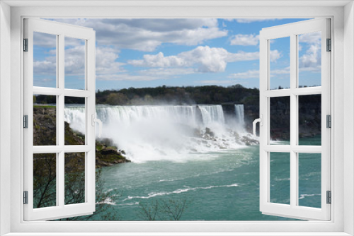 Fototapeta Naklejka Na Ścianę Okno 3D - Niagara Falls waterfall on bright spring day with clouds and blue sky as seen from Ontario, Canada