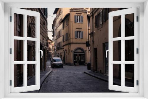 Fototapeta Naklejka Na Ścianę Okno 3D - Narrow street and buildings with parked white van in Florence Italy, at dawn.