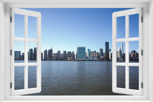 Fototapeta Naklejka Na Ścianę Okno 3D - Cityscape of Manhattan over river with blue sky, New York