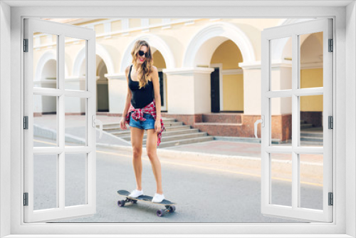 summer holidays, extreme sport and people concept - happy girl riding skateboard on city street