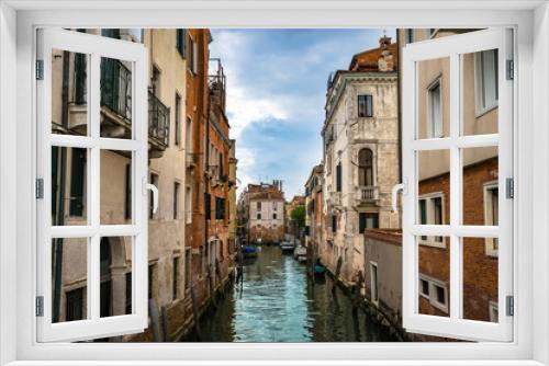 Fototapeta Naklejka Na Ścianę Okno 3D - Panoramic view on famous Grand Canal among historic houses in Venice, Italy at cloudy day with dramatic sky, wood bridge and sitting woman on the foreground.