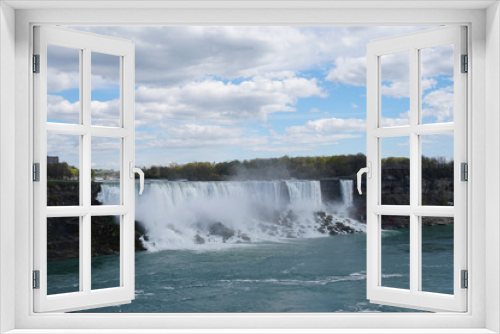 Fototapeta Naklejka Na Ścianę Okno 3D - Niagara Falls waterfall on bright spring day with clouds and blue sky as seen from Ontario, Canada