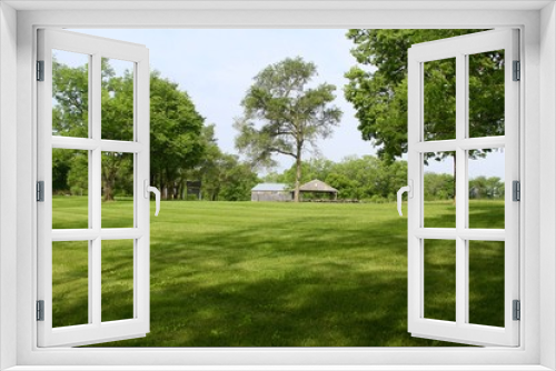 Fototapeta Naklejka Na Ścianę Okno 3D - The parks grass landscape with the barn and buildings in background.