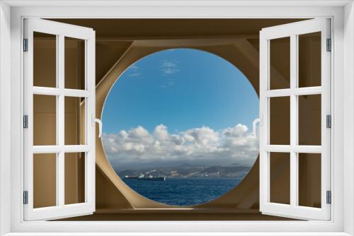 Fototapeta Naklejka Na Ścianę Okno 3D - View of Las Palamas and the ocean on a clear blue sky day thru an open window on a cruise ship