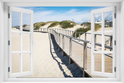Fototapeta Naklejka Na Ścianę Okno 3D - Wooden promenade at european sandy beach near sea with running man, Beach in portugal, Jogging trail, Sand dunes with a wooden footbridge for pedestrians