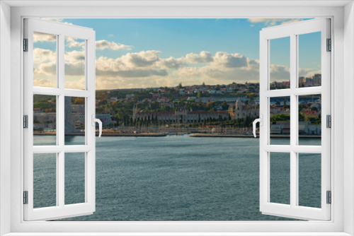 Fototapeta Naklejka Na Ścianę Okno 3D - View of Lisbon, Portugal Tagus River shore including the Explorers Monument, the Jeronimos Monastery and the Estádio do Restelo stadium in late afternoon light on a clear day