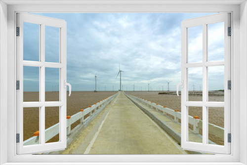Fototapeta Naklejka Na Ścianę Okno 3D - Clean energy, wind power plant with a pathway to the giant wind turbines at sea to provide electricity for human life.