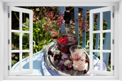 Fototapeta Naklejka Na Ścianę Okno 3D - Karafka z nalewką kieliszki i kwiaty na tacy w ogrodzie