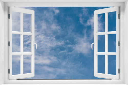 Blue sky background with tiny clouds. White fluffy clouds in the blue sky