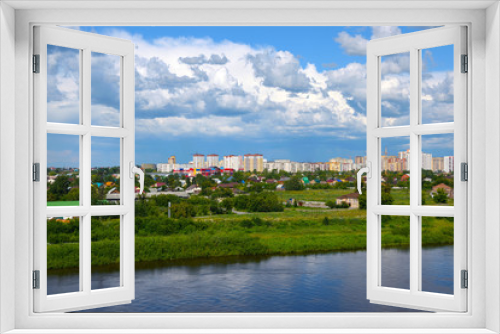 Fototapeta Naklejka Na Ścianę Okno 3D - Construction of a new microdistrict in the Siberian city against the backdrop of the river and ship..