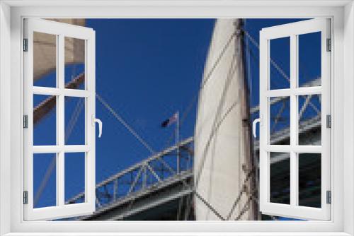 Fototapeta Naklejka Na Ścianę Okno 3D - Looking Up to Auckland Harbour Bridge through the Sails of Yacht