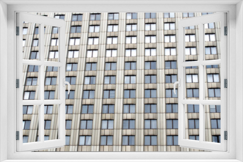 Fototapeta Naklejka Na Ścianę Okno 3D - Many windows a tall urban building of monophonic color