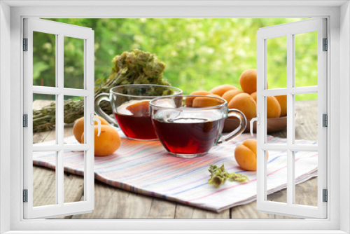 Fototapeta Naklejka Na Ścianę Okno 3D - Herbal tea and apricots on a wooden table.