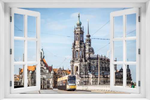 Fototapeta Naklejka Na Ścianę Okno 3D - View on the riverside of Elbe river with catholic church, city gates and tram during the sunny weather in Dresden city, Germany