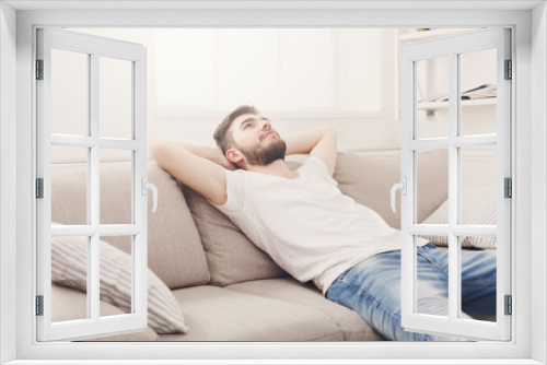 Handsome young man relaxing on the couch at home