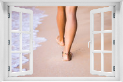 Fototapeta Naklejka Na Ścianę Okno 3D - Woman steps on sand  near ocean beach while walking
