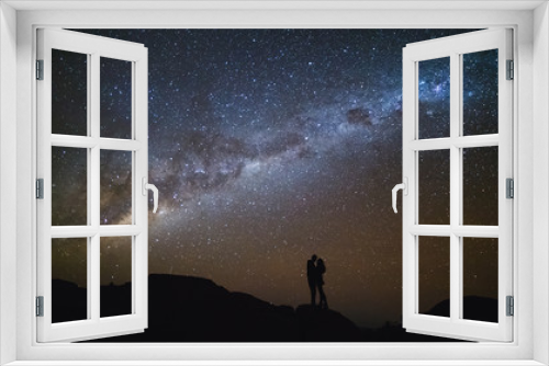 Fototapeta Naklejka Na Ścianę Okno 3D - Landscape with Milky Way. Night sky with stars and silhouette of a couple kissing on the mountain.