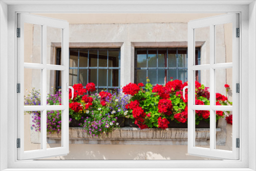 Fototapeta Naklejka Na Ścianę Okno 3D - An old wooden window. The facade of an English house in colors. English garden. Background. Summer. Sunny day. Flower.