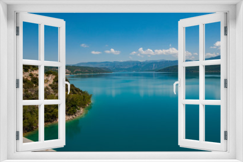 Fototapeta Naklejka Na Ścianę Okno 3D - Lac de haute montagne avec plage et ciel bleu se reflétant dans une eau bleue turquoise en forme de carte postale