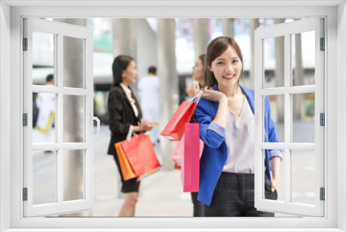 Asian Woman holding Shopping bag with Attractive smile at city. Woman shopping concept.