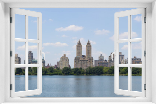 Fototapeta Naklejka Na Ścianę Okno 3D - Central Park West skyline and the Jacqueline Kennedy Reservoir in New York City with apartment skyscrapers over lake with fountain in midtown Manhattan and lake reflection 