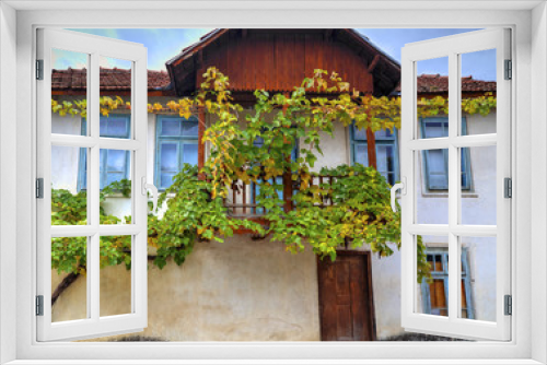 Fototapeta Naklejka Na Ścianę Okno 3D - Facade of stylish old house decorated with fresh green vine