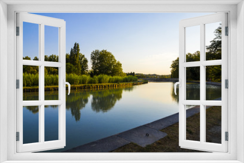 Fototapeta Naklejka Na Ścianę Okno 3D - The Canal du Midi in Beziers at sunset, a long canal that connects the Atlantic Ocean with the Mediterranean Sea in Southern France. A world heritage site since 1996