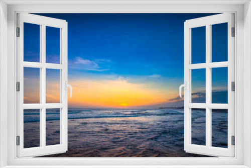Fototapeta Naklejka Na Ścianę Okno 3D - Panorama of Tropical Sunset Beach on the ocean. Surfing Beach with Surfers on the Horizon. Colorful Ocean Background View at Sunset Time. Amazing Beautiful sky and long exposure Waves for Background. 