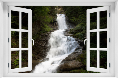 Fototapeta Naklejka Na Ścianę Okno 3D - Mountain waterfall in a forest in Valle d'Aosta, flows between trees and rocks.