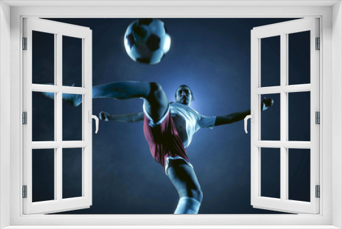 Fototapeta Naklejka Na Ścianę Okno 3D - Soccer player kicks the ball on the soccer stadium. He wear unbranded sports clothes. Stadium and crowd made in 3D.